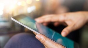 Close up picture of someone holding a tablet