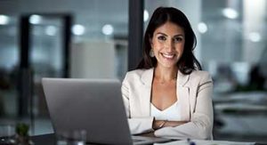 Woman in office sitting in front of laptop.