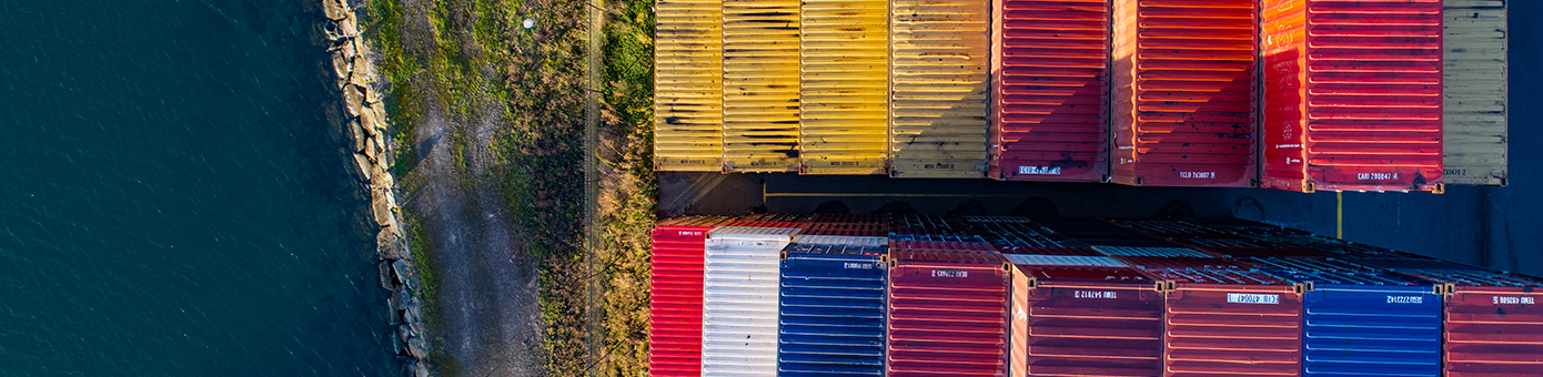 birds eye view of colourful shipping containers next to ocean.